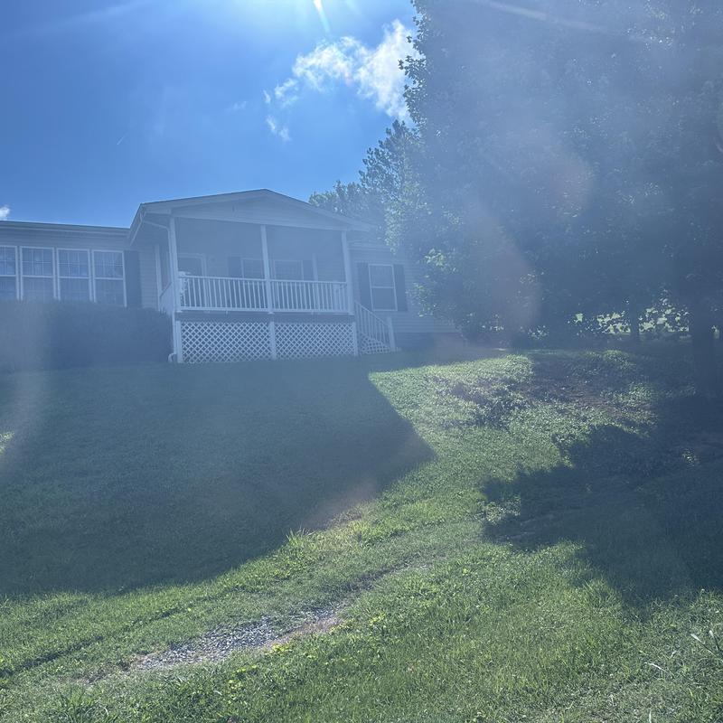 Residential roof with porch and green lawn on sunny day