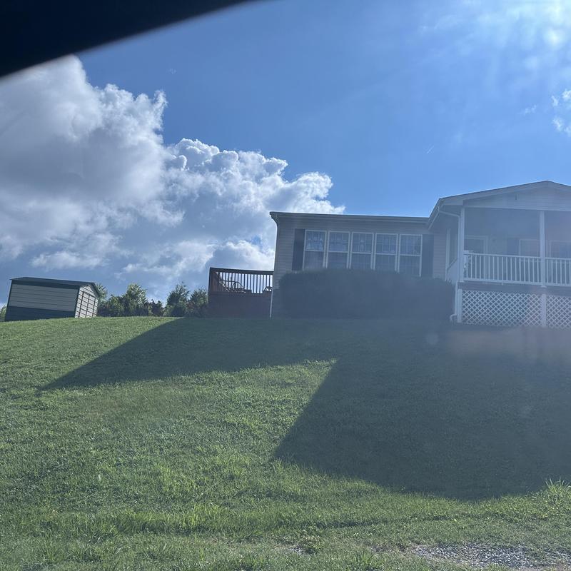 Residential roof with deck and lawn on hill