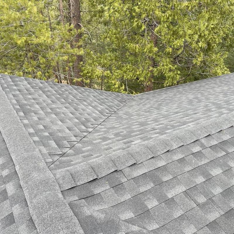 Lifetime gray GAF asphalt roof installation with ridge caps
