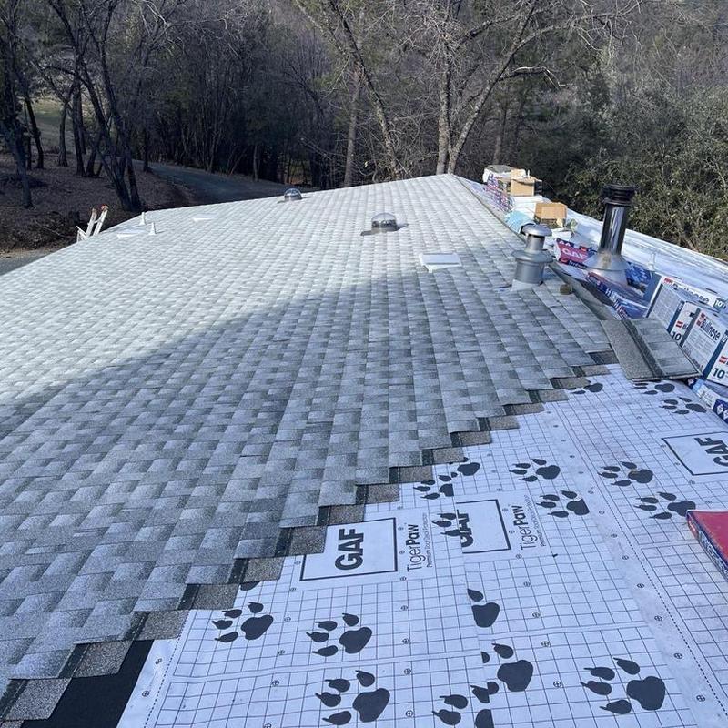 GAF asphalt roof installation with ventilation pipes