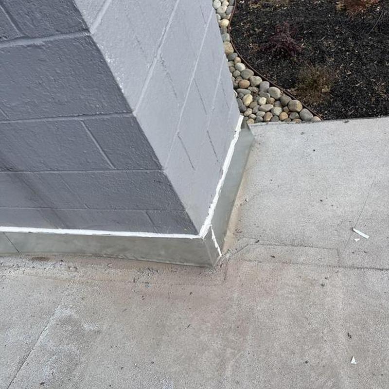 Concrete foundation sealing along masonry wall corner