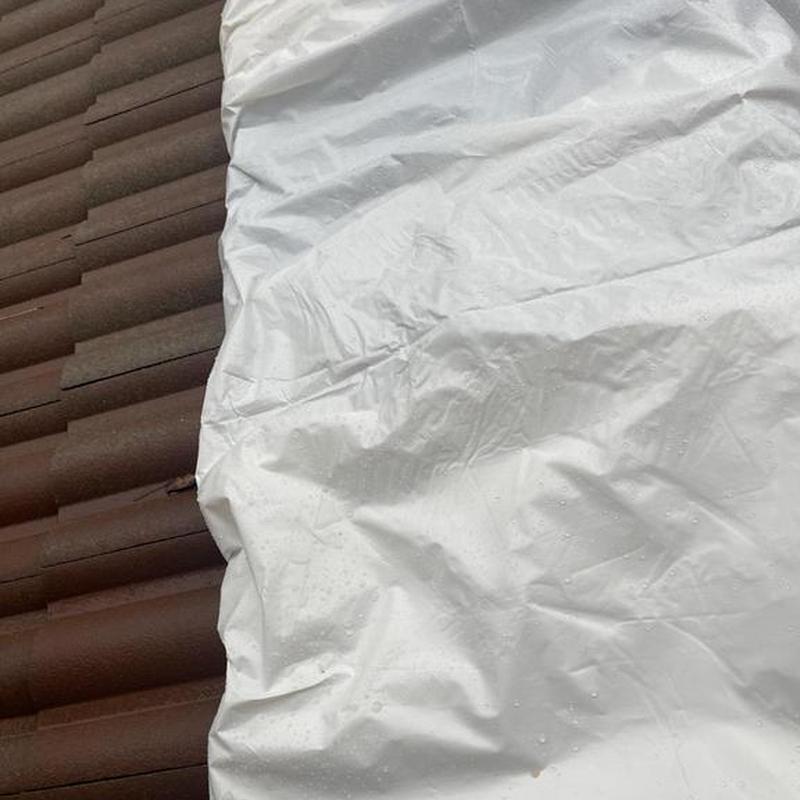 Tile roof with protective white tarp covering