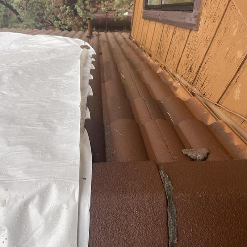 Tile roof broken section with plastic tarp cover