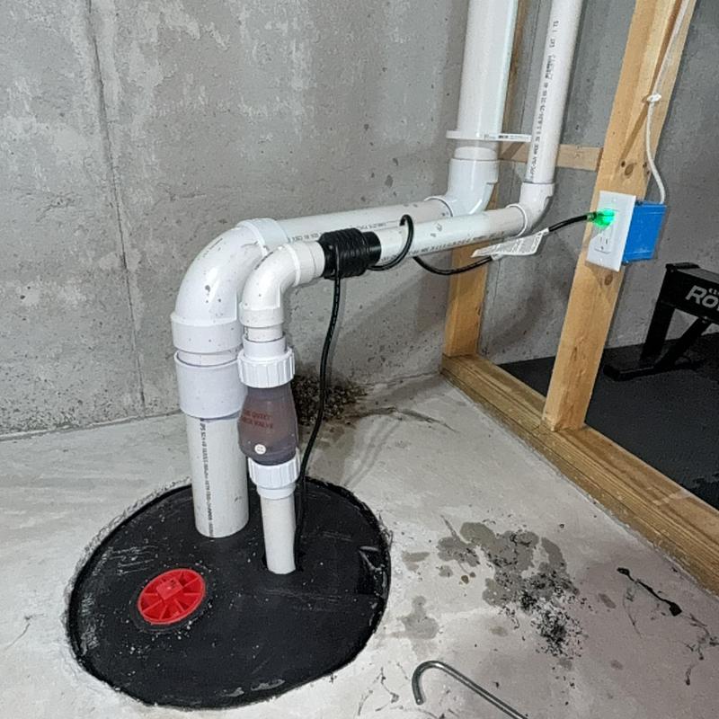 Sump pump with PVC discharge pipe and electrical outlet