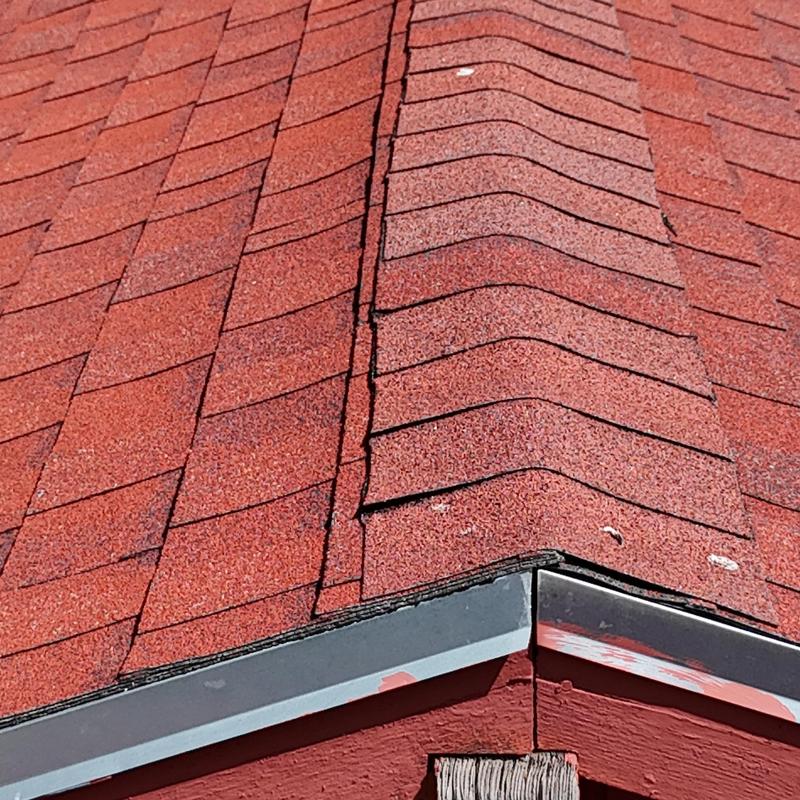 Asphalt shingle roof ridge with valley metal flashing