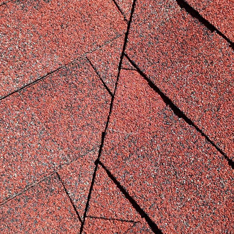 Asphalt shingle roof close-up showing wear and cracks