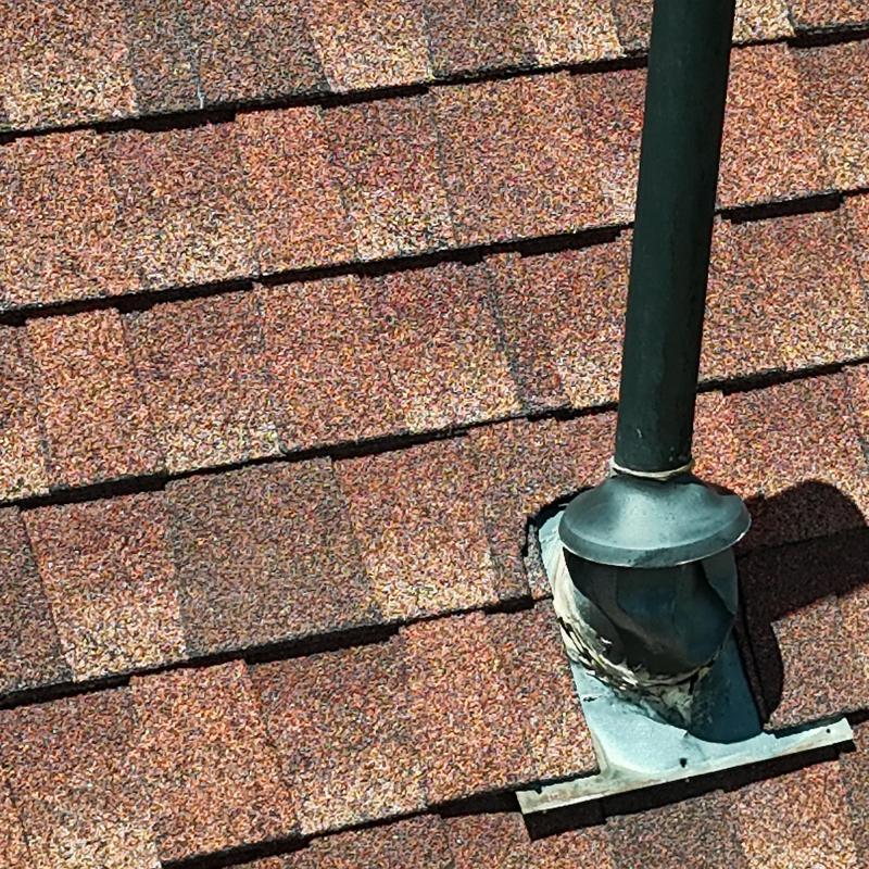 Asphalt shingle roof with pipe flashing and sealant
