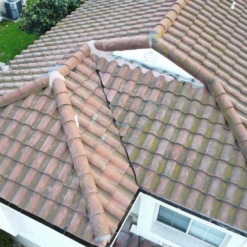 Tile roof ridge and valley with visible repairs Tile roof ridge and valley with visible repairs