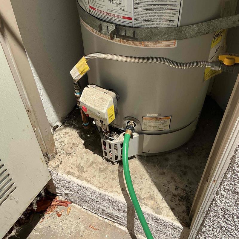 Storage tank water heater with drainage hose attached