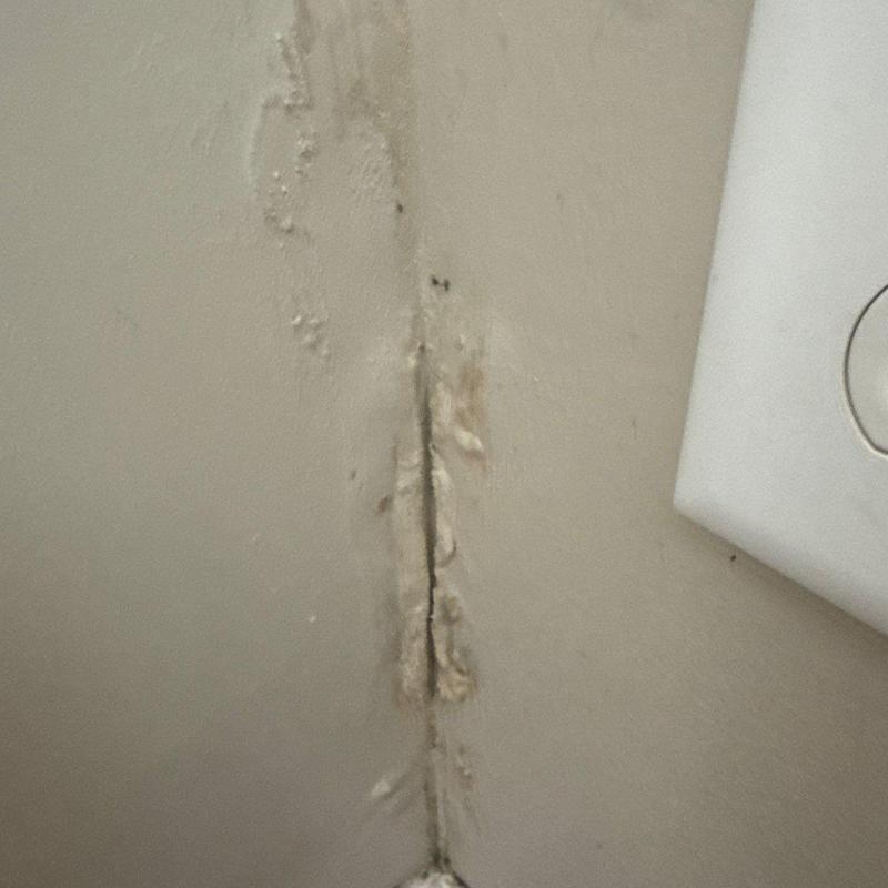 Drywall corner with water damage and peeling paint