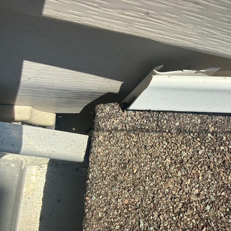 Asphalt shingle roof edge with minor hail damage