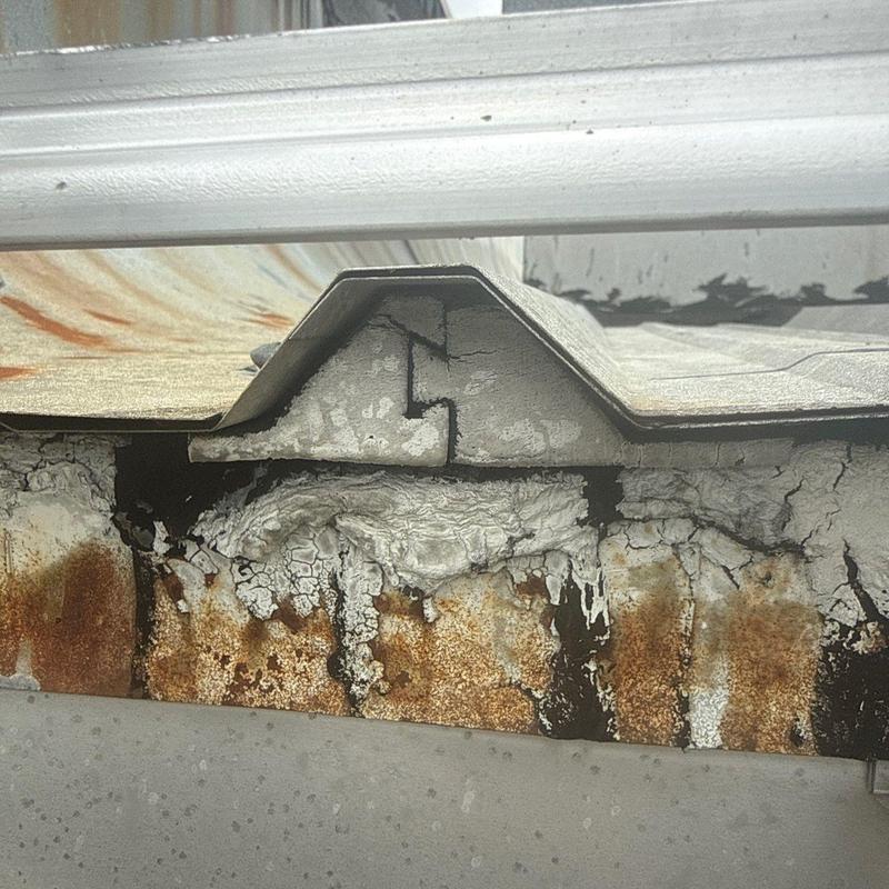 Metal roofing panel with rust and corrosion damage