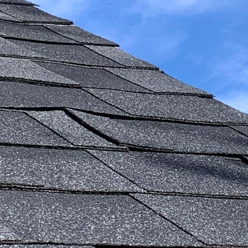 Roof shingles with hail damage and lifting edges