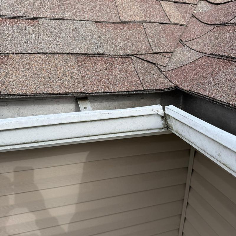 Gutter system with roof shingle edge and corner joint