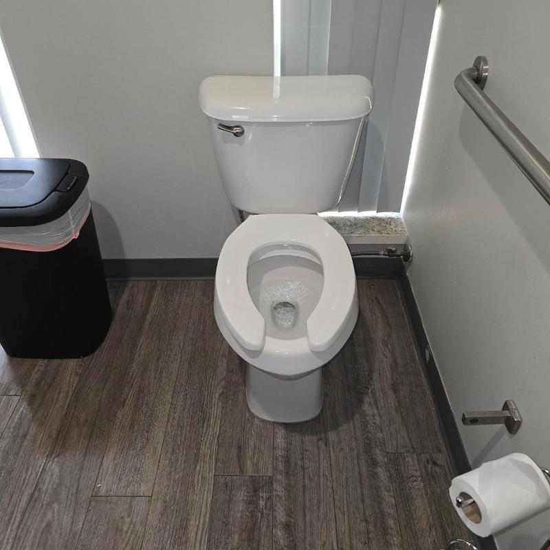 Toilet with seat and tank in public restroom