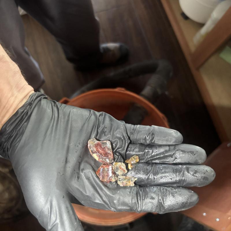 Water heater sediment removal with black glove hand