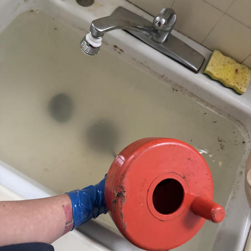 Bathtub drain cleaning with red drain snake tool