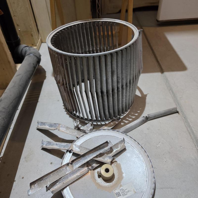 Indoor blower motor wheel and broken fan blades on floor