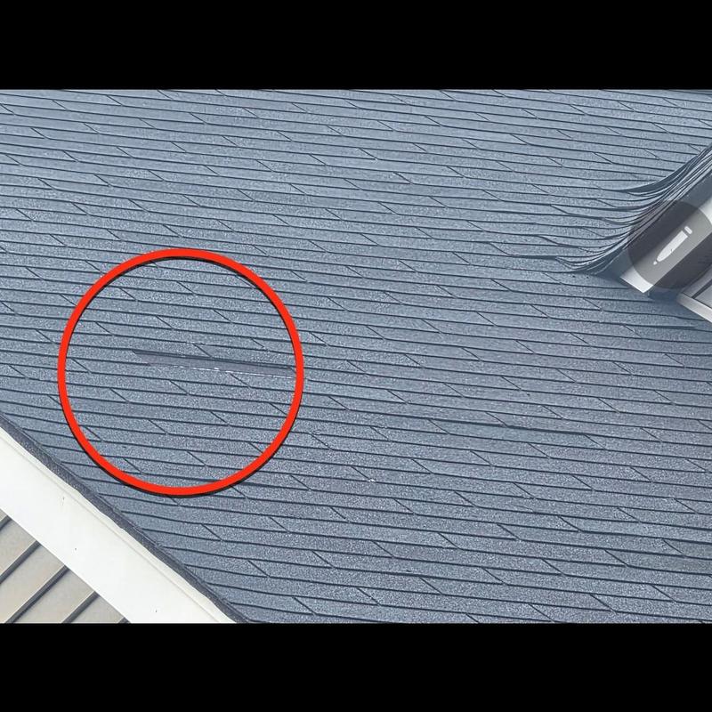 Asphalt roof shingles with wind damage and missing spots