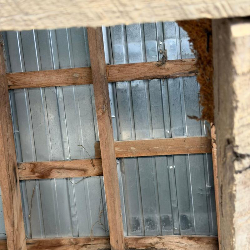 Metal roofing panels with wooden support framing