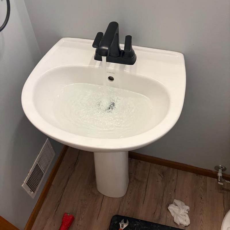 Bathroom sink with black faucet running water Bathroom sink with black faucet running water
