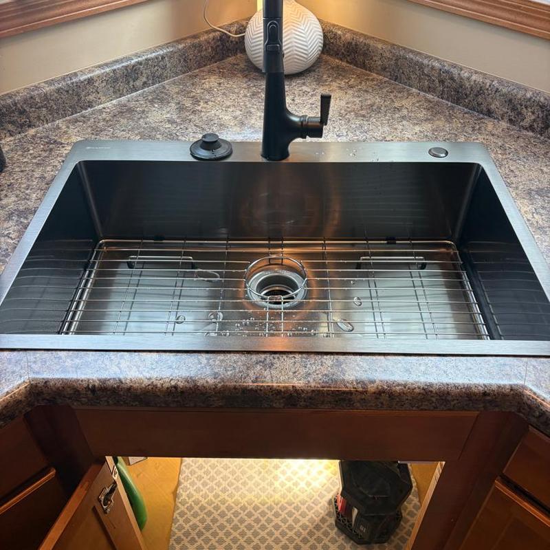 Kitchen sink and black faucet installation with drain grid Kitchen sink and black faucet installation with drain grid