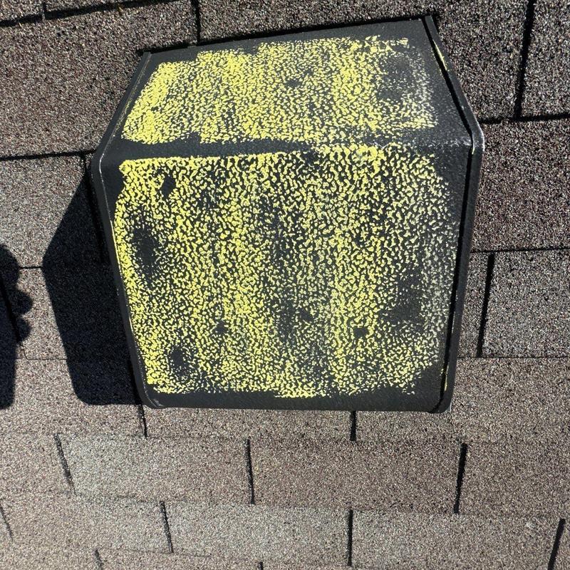 Roof vent with yellow hail damage markings on shingles