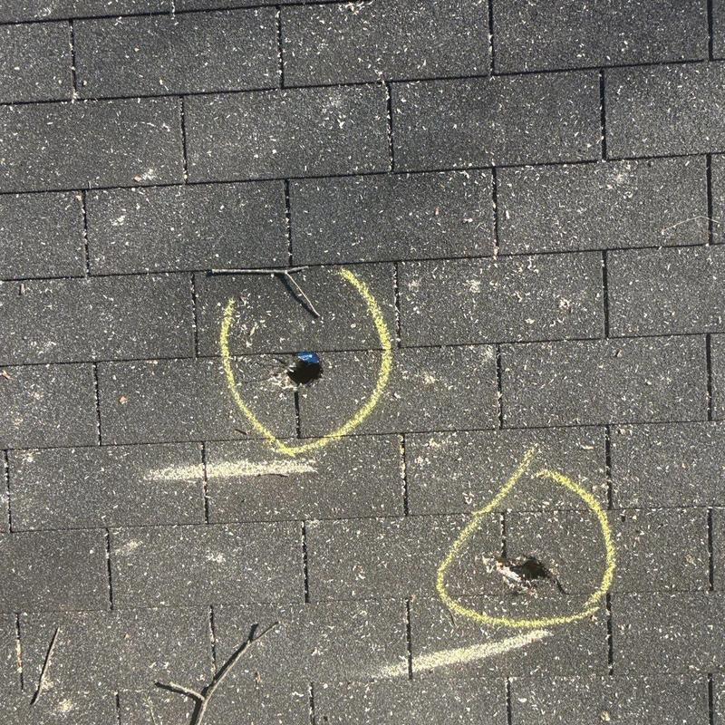 Roof shingles with hail damage marked for repair