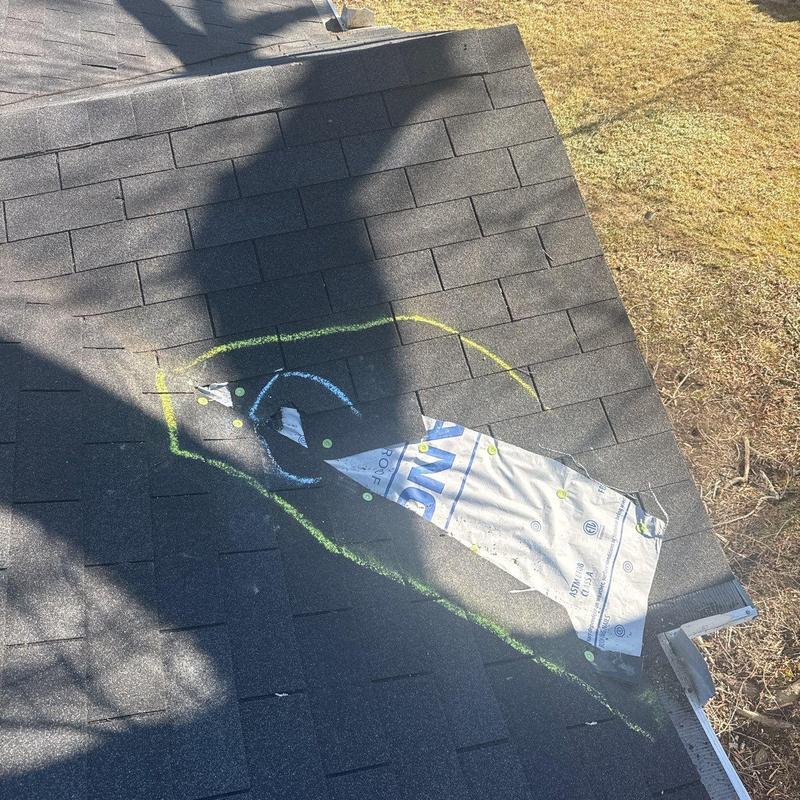 Roof shingles with hail damage marked for repair