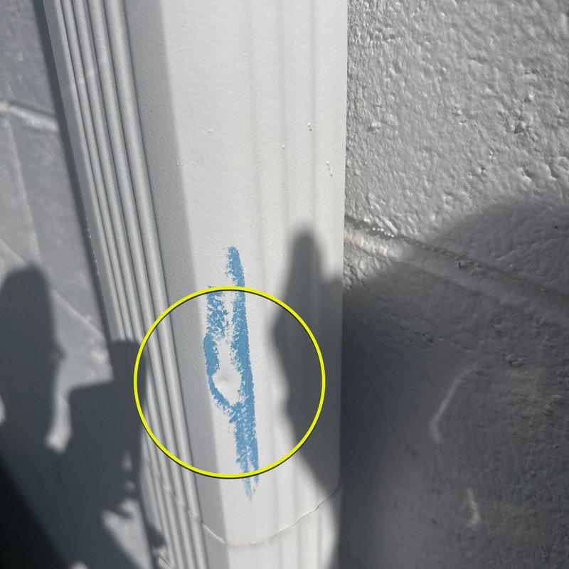 Metal downspout dent with blue chalk marking