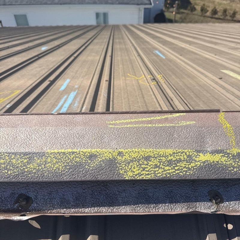 Metal roof panel with hail damage markings