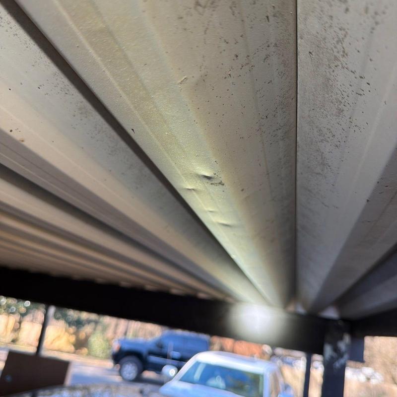 Metal carport roof panel with dent damage