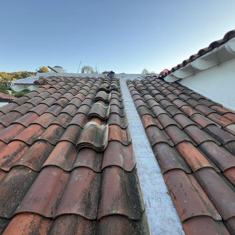 Tile roof ridge with missing and misaligned tiles Tile roof ridge with missing and misaligned tiles
