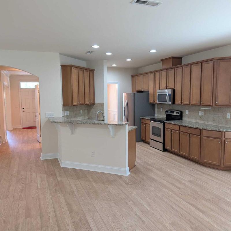 Vinyl plank flooring in open kitchen and hallway
