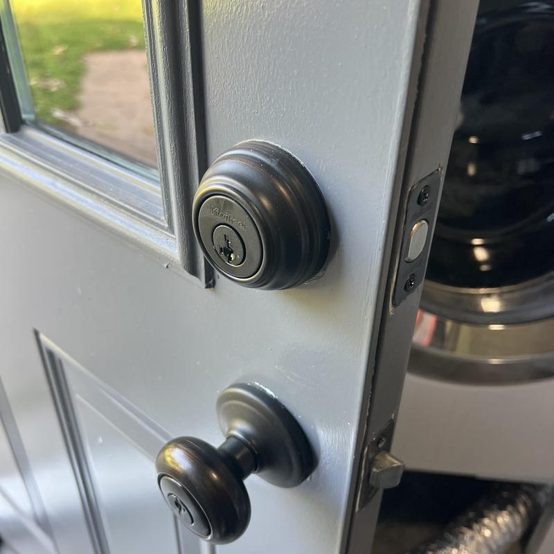 Deadbolt and door knob locks on gray door