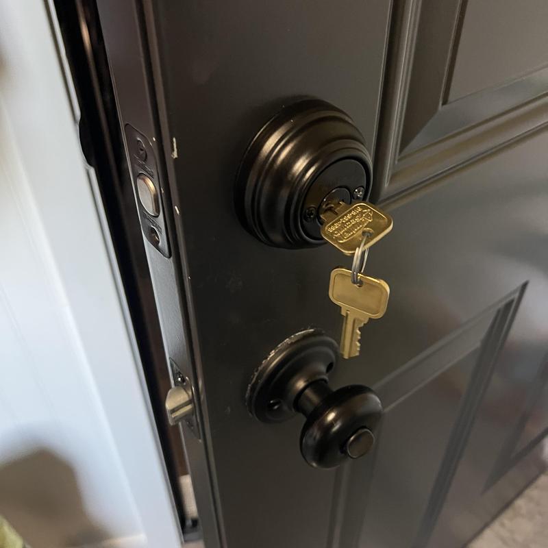 Deadbolt lock with key in black door
