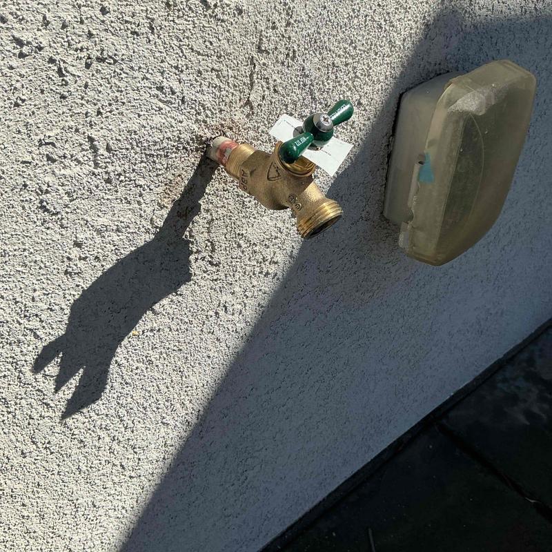 34 hose bib faucet on exterior wall with shadow