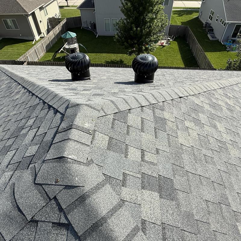 Roof shingles with ridge and turbine vents on residential home Roof shingles with ridge and turbine vents on residential home