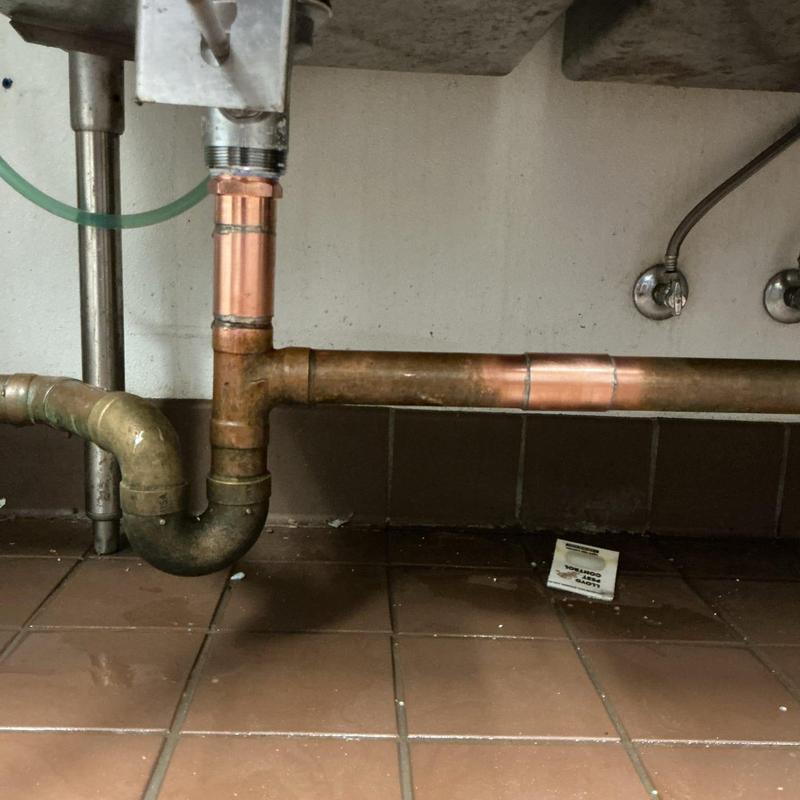 Copper drain pipe with new section under sink