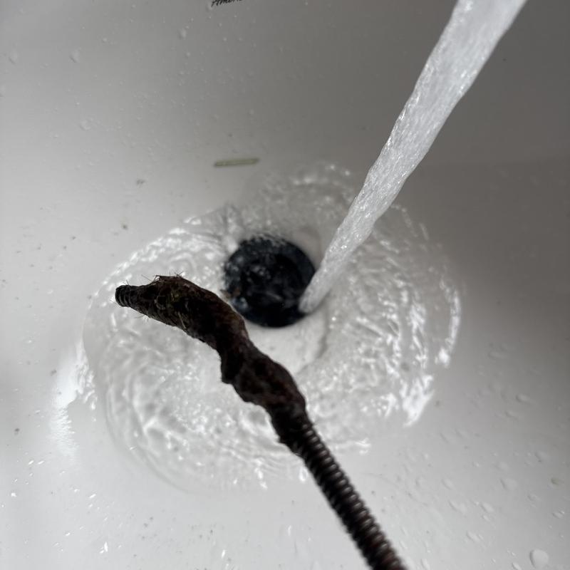 Bathroom basin drain snaking removing hair buildup