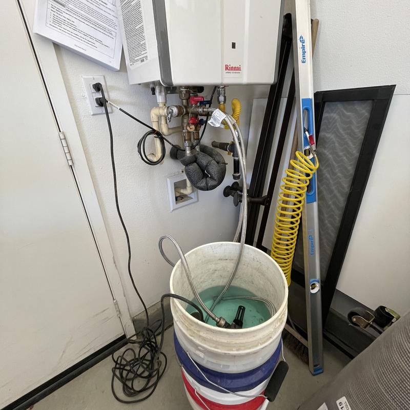 Tankless water heater descaling with flushing bucket