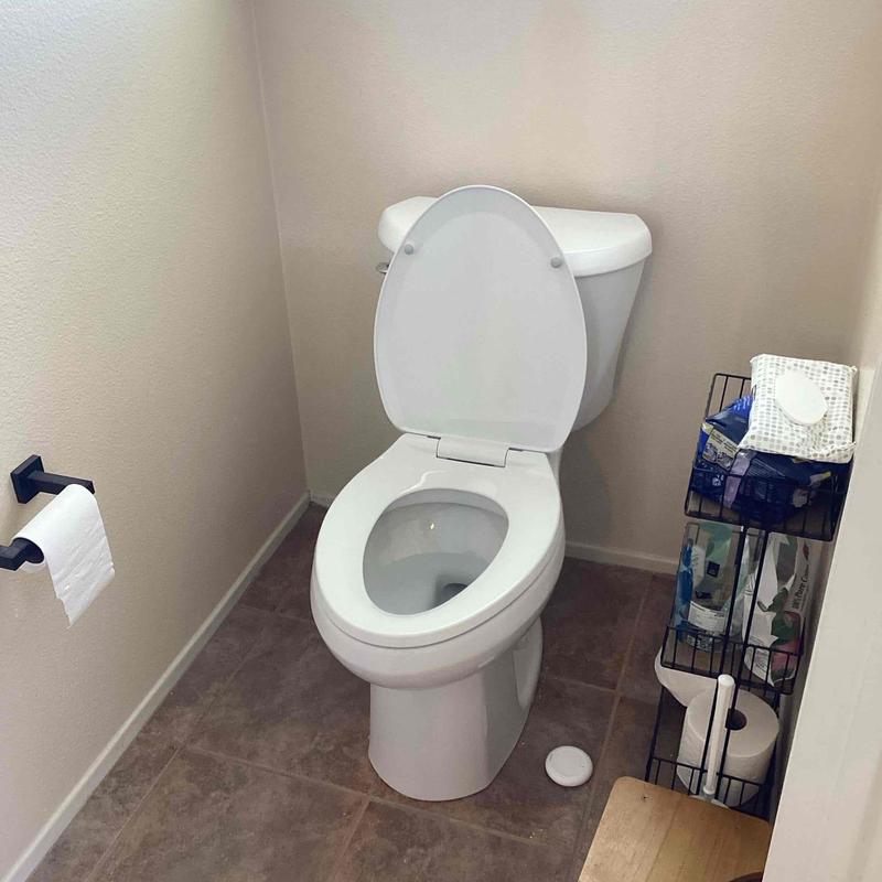 Toilet with open lid in residential bathroom corner