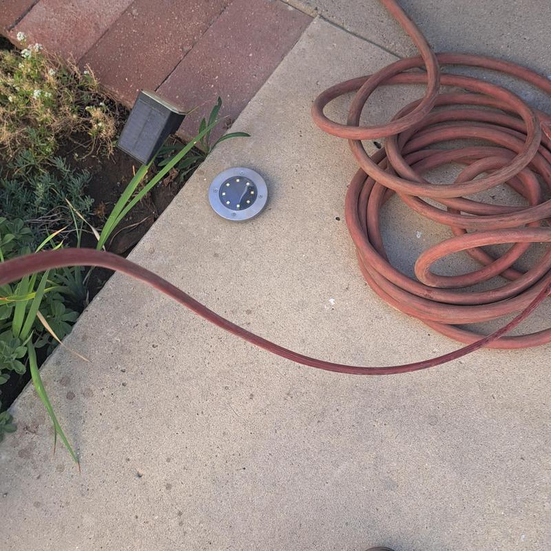 Mini jetter hose coiled on sidewalk near clean out valve Mini jetter hose coiled on sidewalk near clean out valve