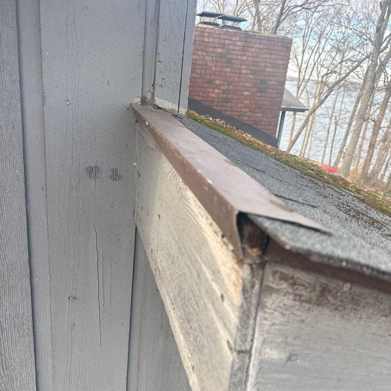 Roof flashing with damaged edge and aged shingles