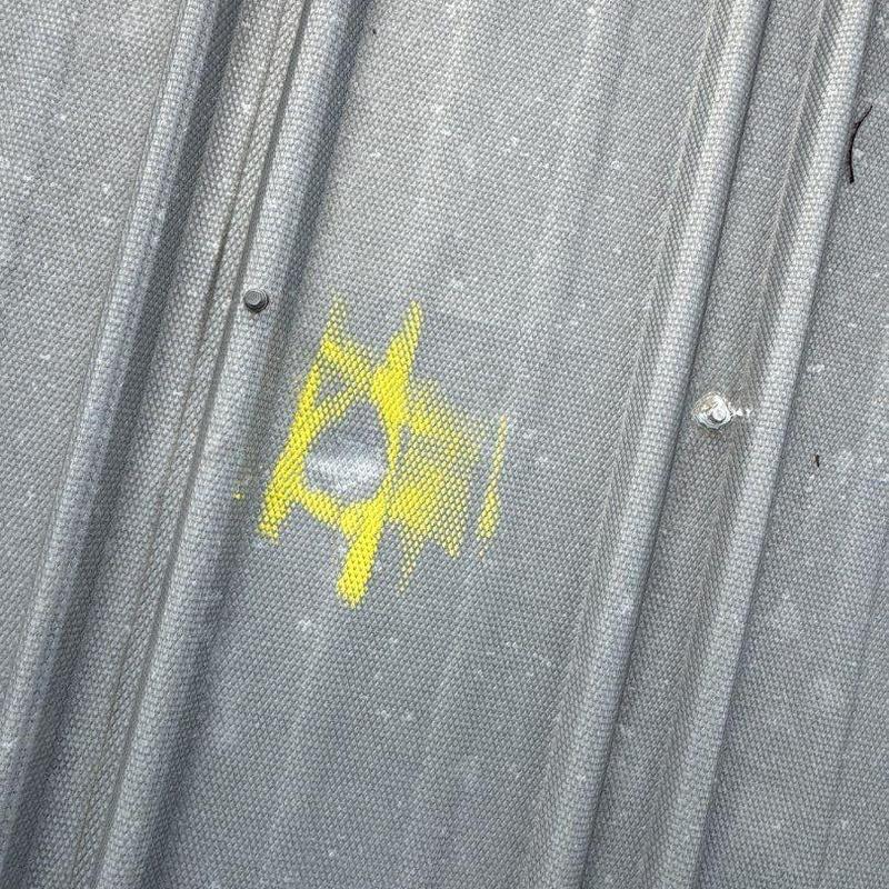 Metal roof panel hail damage marked with yellow paint