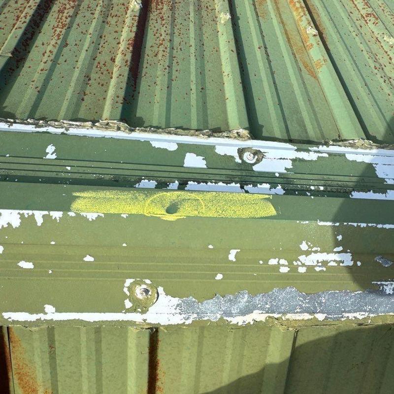 Metal roof panel with rust and paint peeling damage