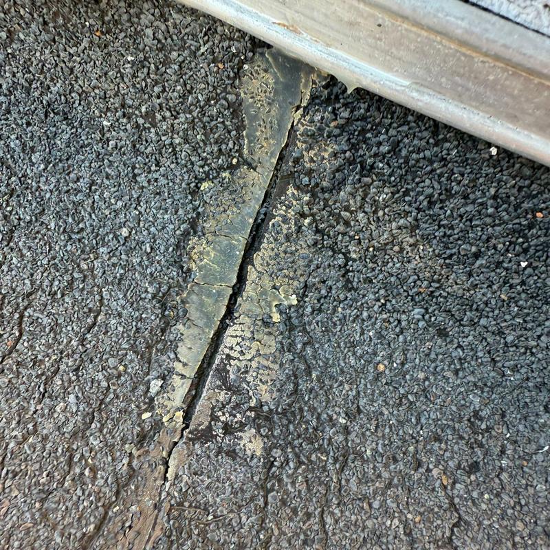 Flat roof membrane showing cracked and damaged seams