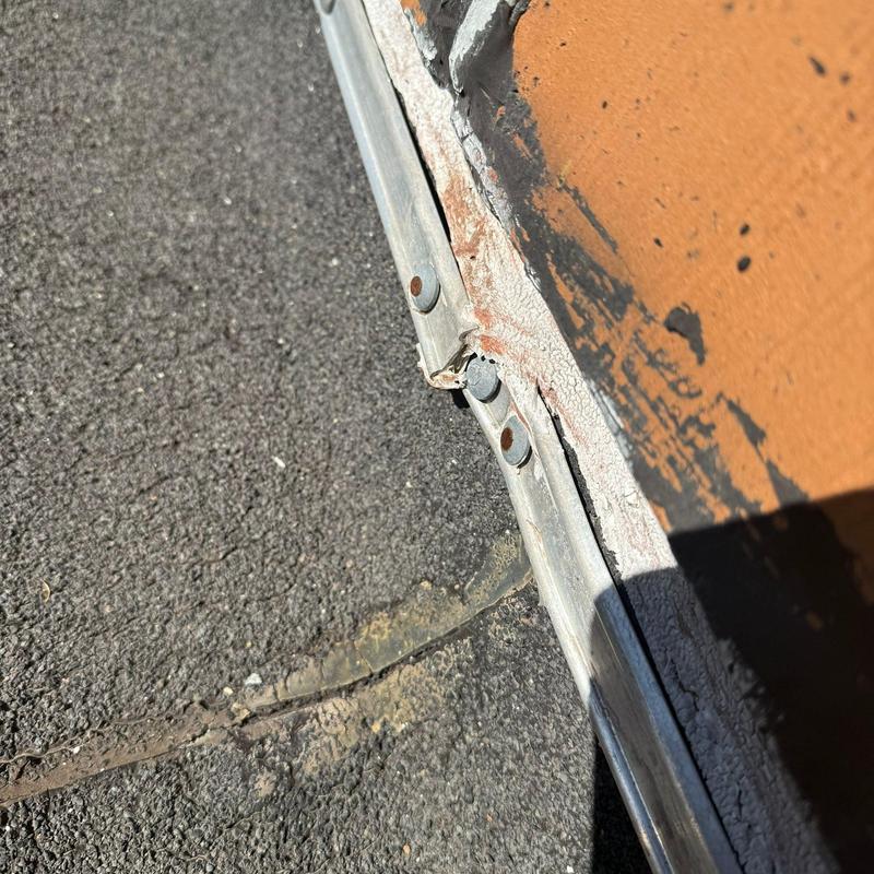 Metal roof flashing with rust and sealant deterioration