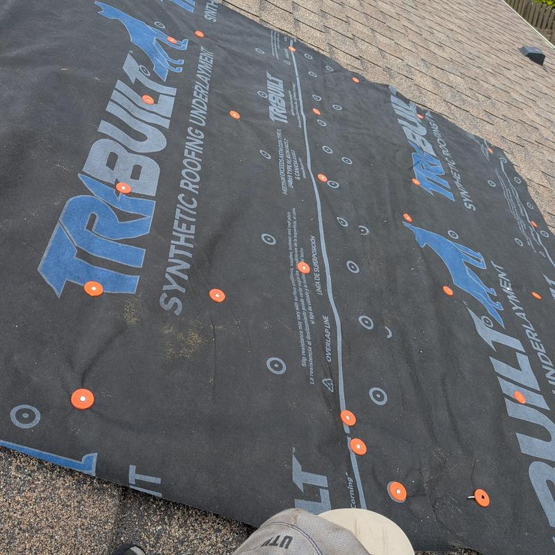 Synthetic roofing underlayment secured on shingled roof