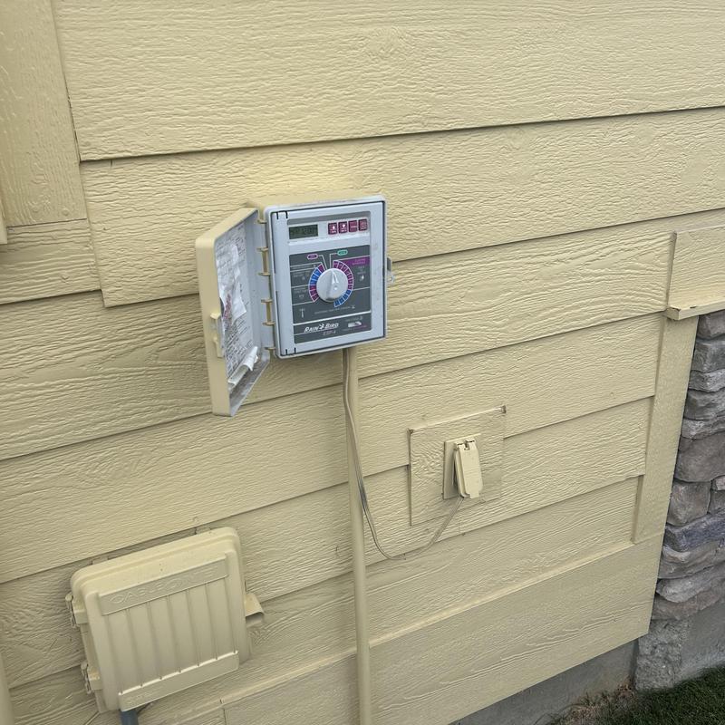 Sprinkler control clock with open panel and power cord Sprinkler control clock with open panel and power cord